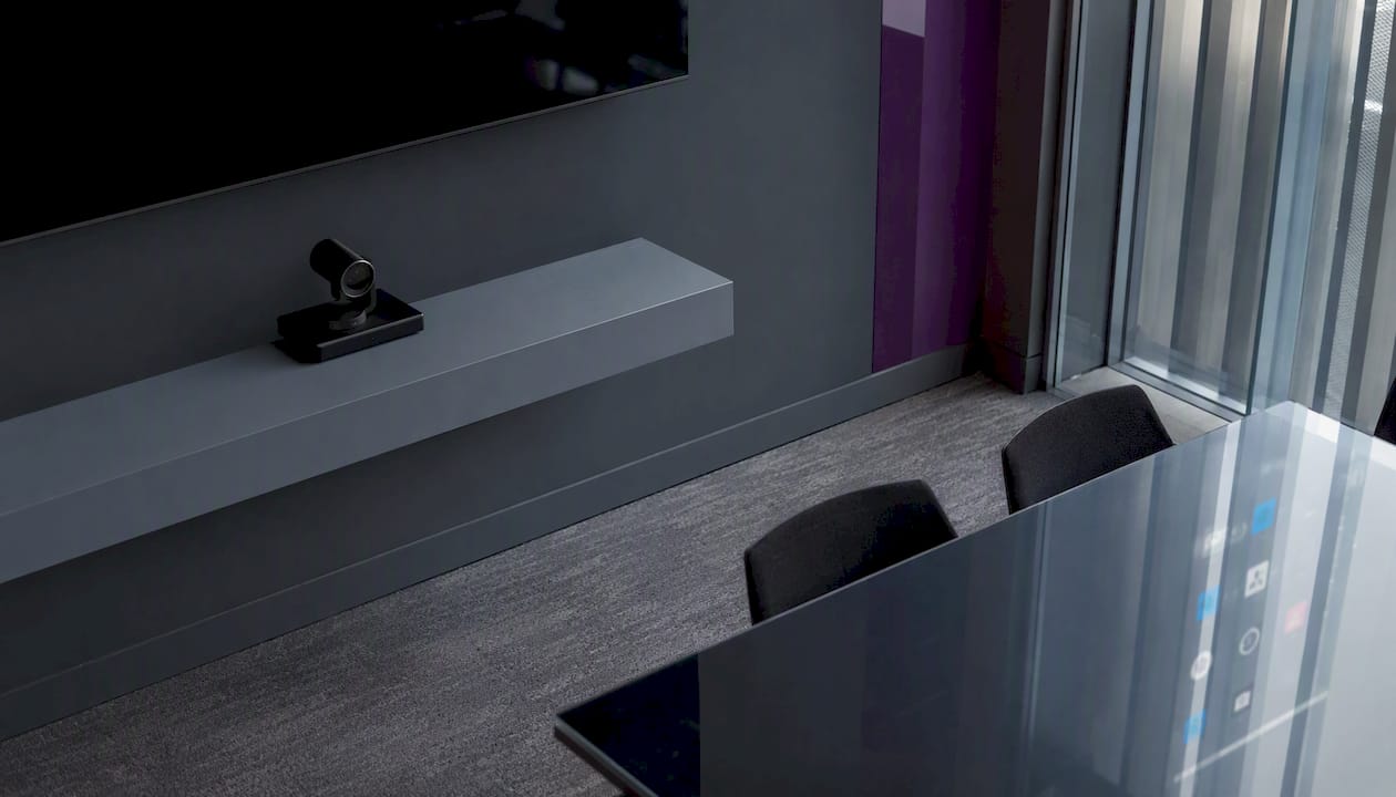 Office tech setup with conferencing camera and app reflections