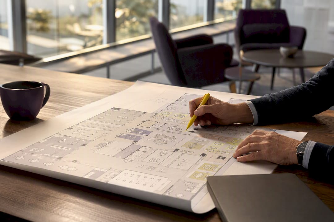 Hands marking hybrid office floor plan