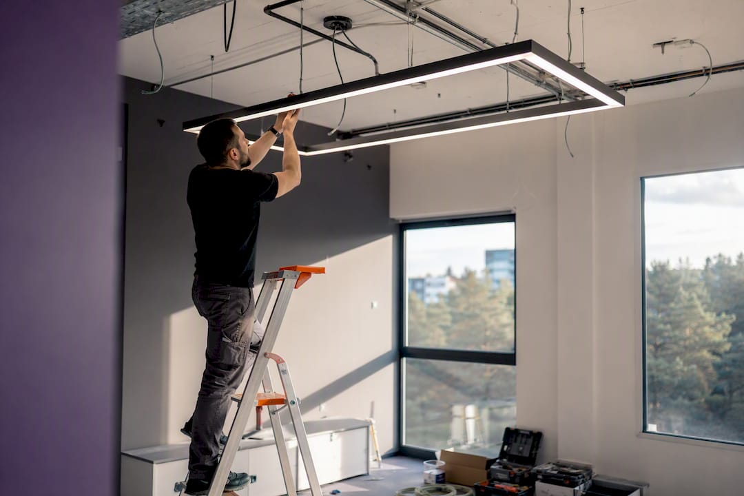 Technician adjusting LED office light panel