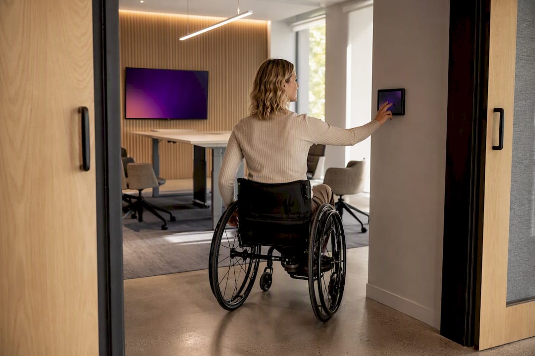 Wheelchair user accessing meeting room controls