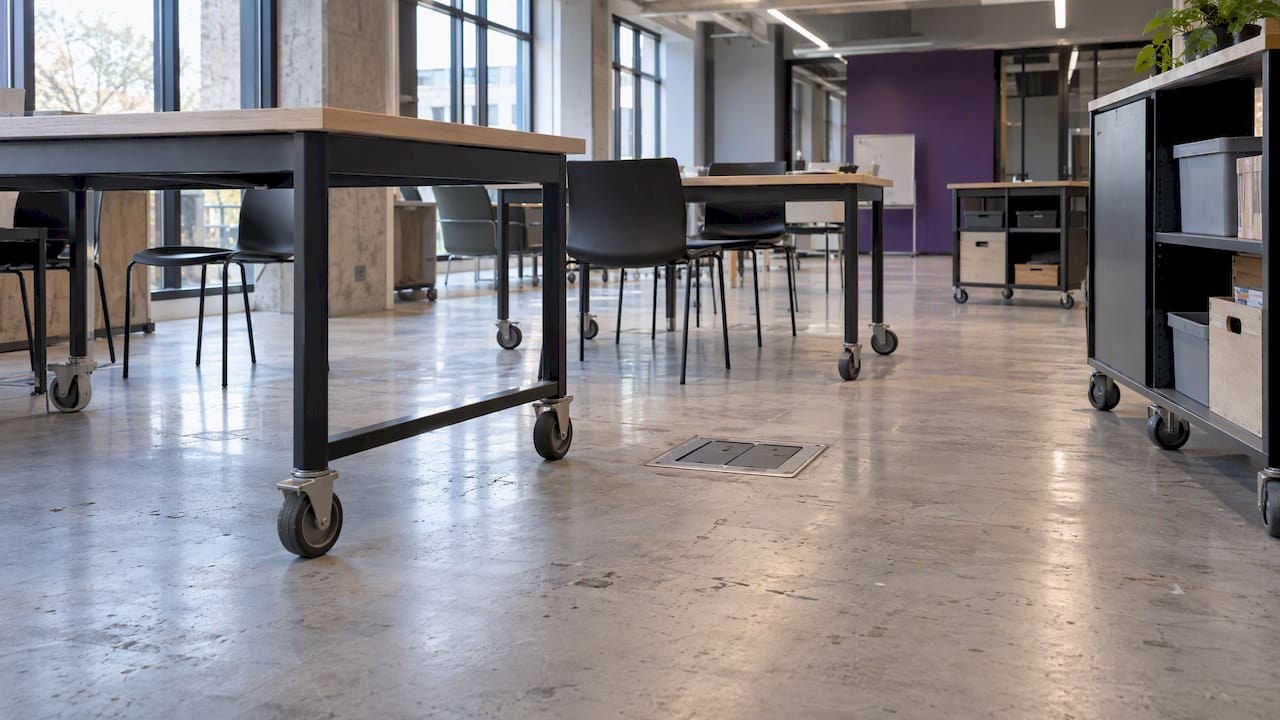 Workshop tables on castors beside a floor power box